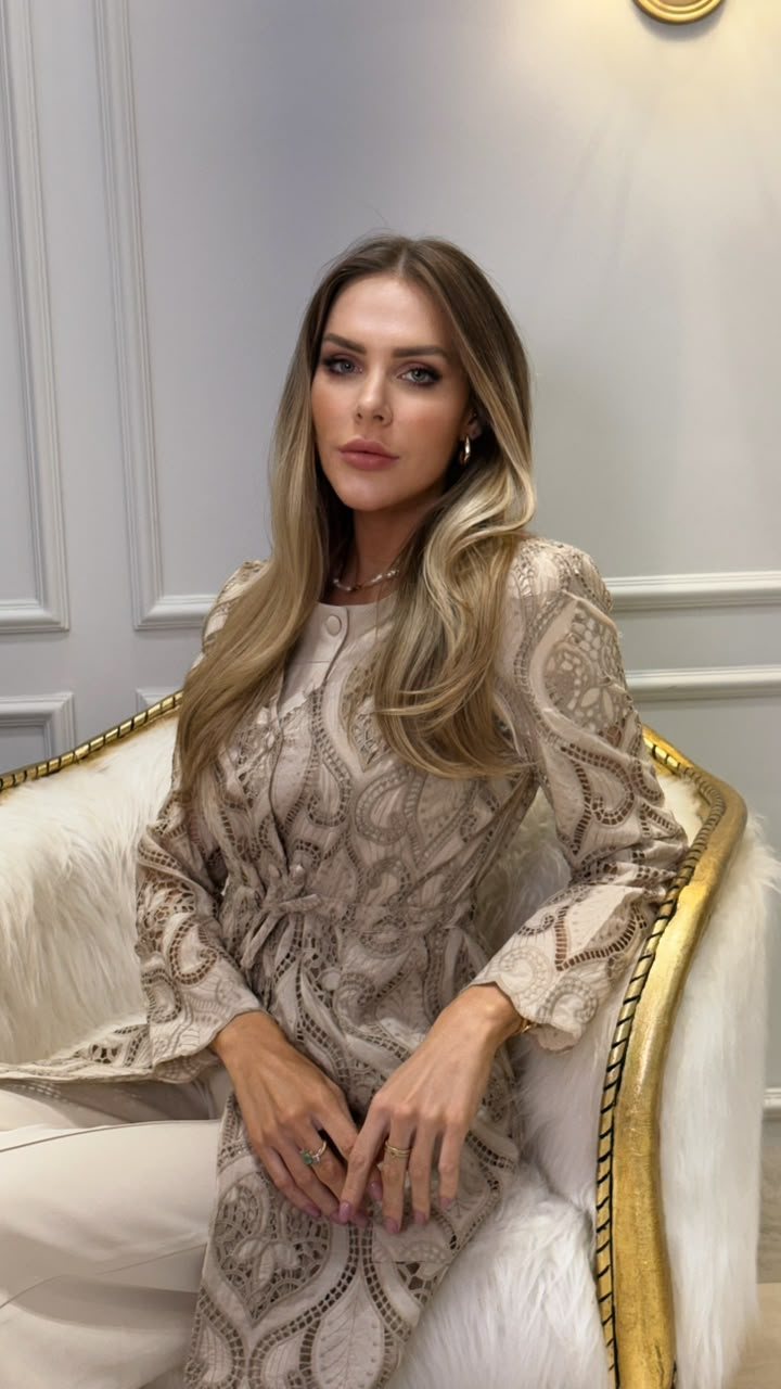 Flávia Calvi, nutricionista em Maringá, sentada numa poltrona branca com moldura dourada